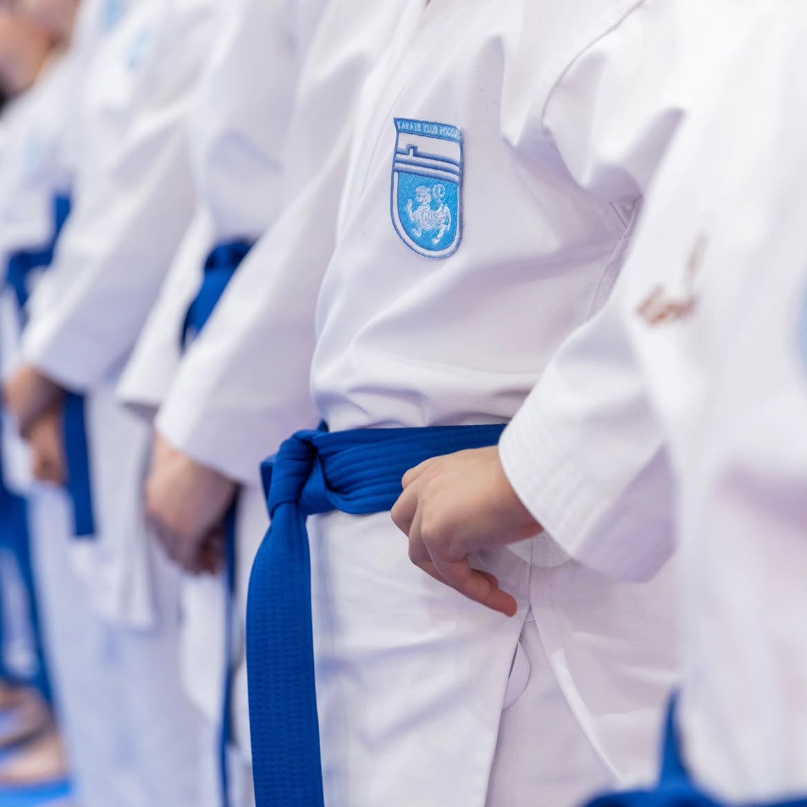 Detail of a karate uniform with the Podgorica Karate Club crest and a blue belt