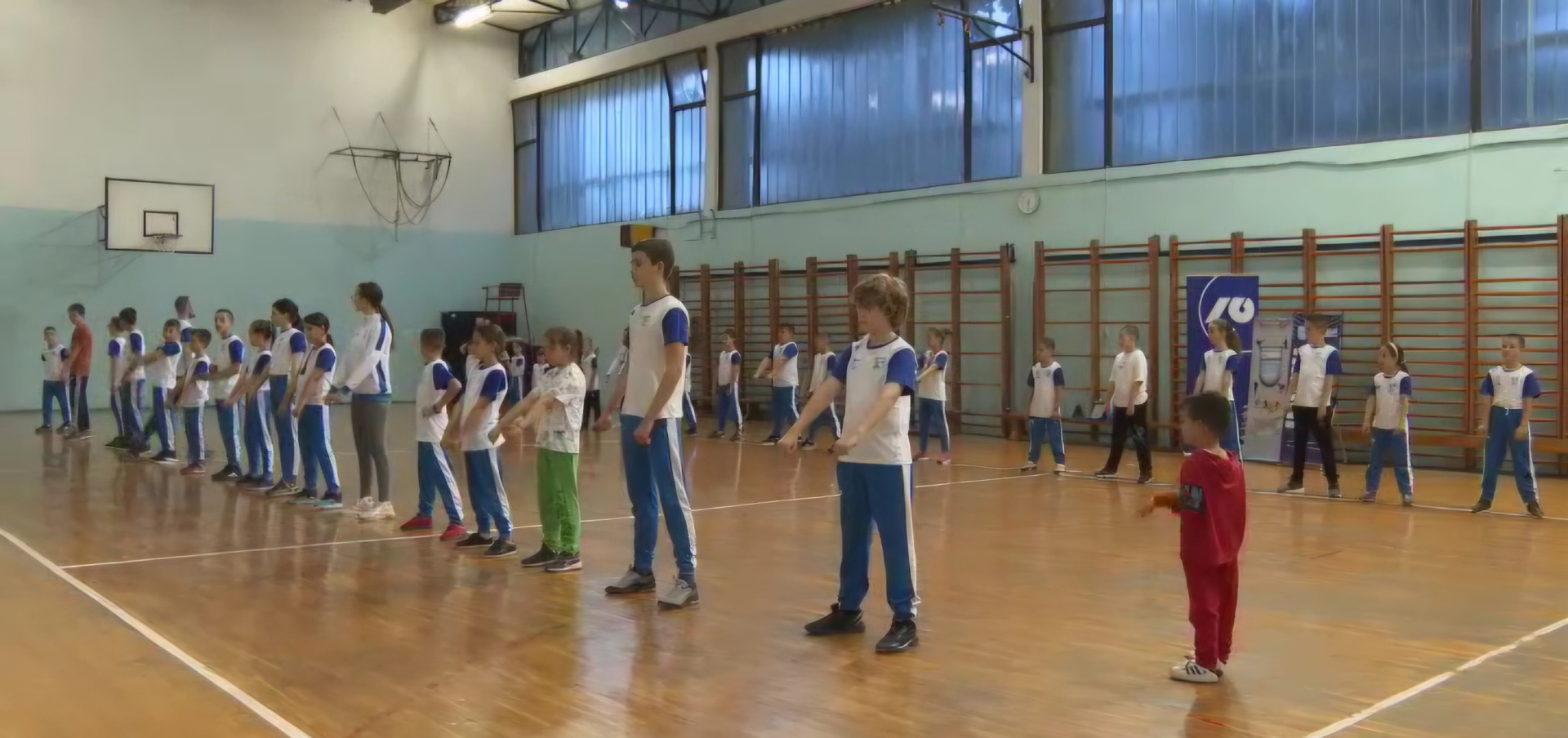Children from Podgorica Karate Club training together in a school gym